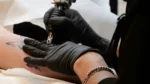Tatuadora realizando un tatuaje de las fases de la luna.