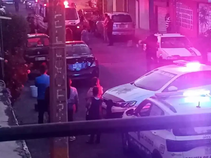 Patrullas y vecinos en la calle donde sujetos atacaron a balazos a una mujer en la colonia Popular Castillotla.