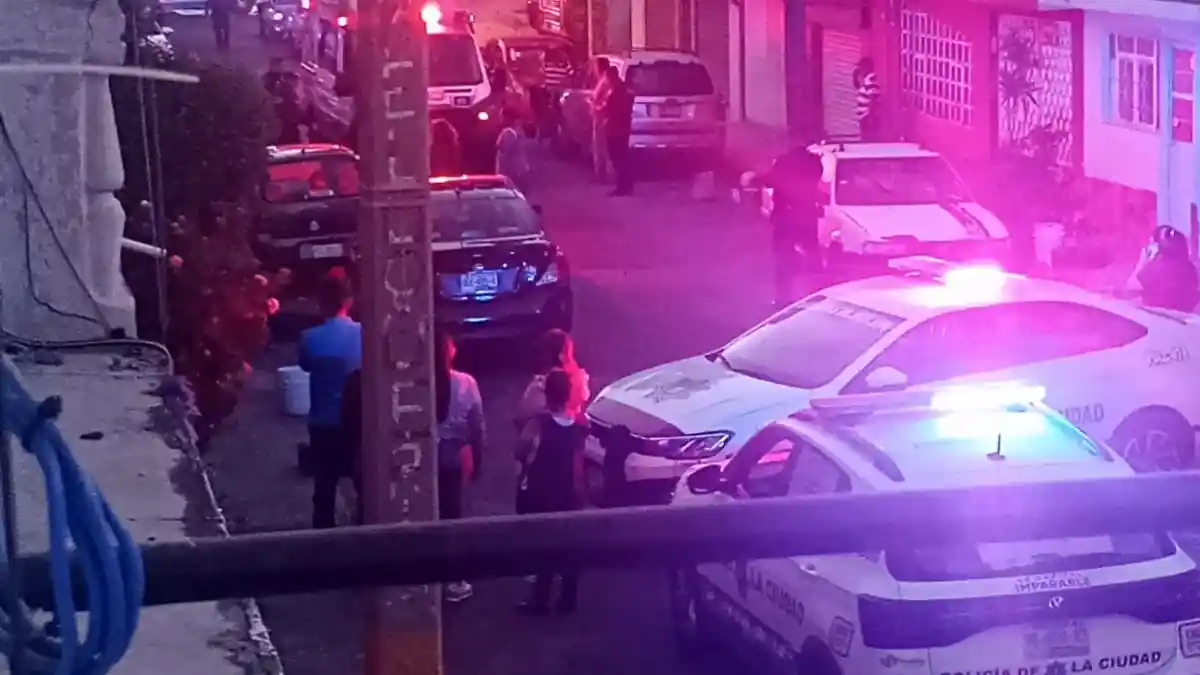 Patrullas y vecinos en la calle donde sujetos atacaron a balazos a una mujer en la colonia Popular Castillotla.
