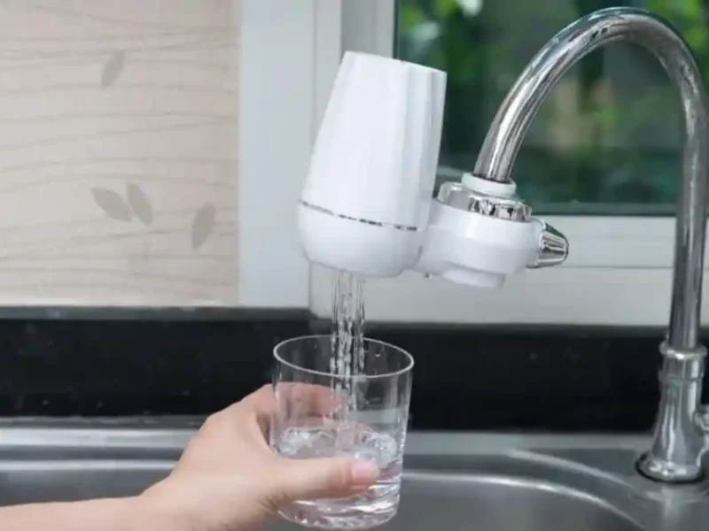 Purificador de agua colocado en el grifo de una tarja.