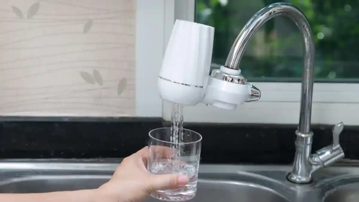 Purificador de agua colocado en el grifo de una tarja.