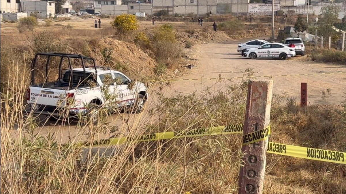 Patrullas de Puebla rodean dos bolsas negras con restos dentro.