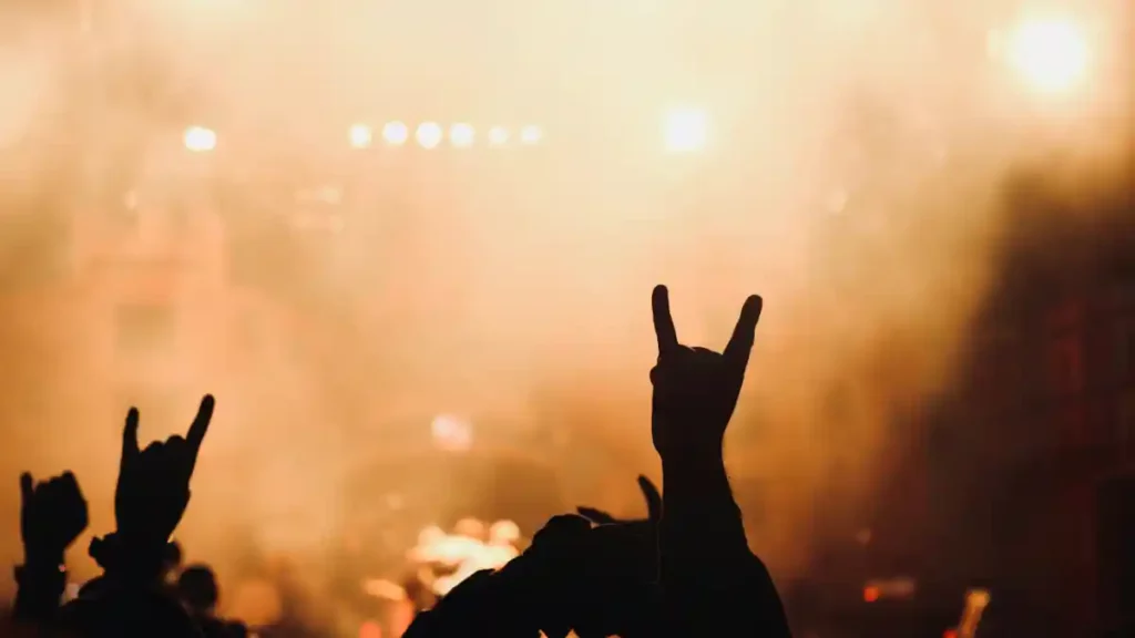 Asistentes de un concierto realizando la mano cornuta, "maloik" o mejor conocido como saludo del rock.